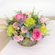 Arrangement floral Agatha rond avec roses roses, œillets verts et feuillage dans une corbeille