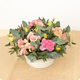 Arrangement floral Nectar fleuri rond avec roses branchues roses, œillets, lisianthus abricot et eucalyptus