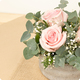 Arrangement floral Velours de rose avec trois roses roses, gypsophile et eucalyptus dans son contenant