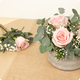 Arrangement floral Velours de rose avec trois roses roses, gypsophile et eucalyptus dans son contenant
