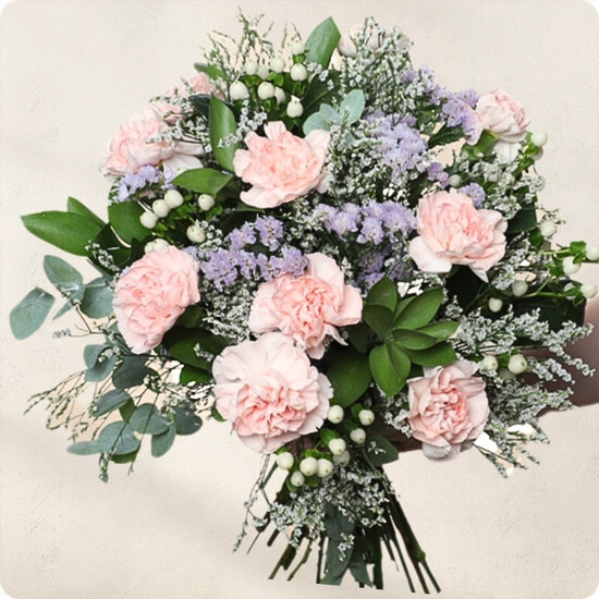 Photo du Bouquet Bienvenue – bouquet rond aux œillets roses, statice lavande, limonium et feuillage vert élégant dans un vase.