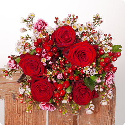 Bouquet Charme de Noël avec des roses rouges intenses et du wax blanc