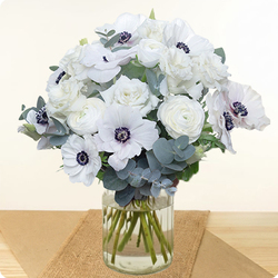 Bouquet rond aux anémones blanches, fleurs fraîches blanches et feuillage élégant. Une création raffinée livrée rapidement en main propre avec 123fleurs.