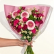Bouquet Octobre Rose rond aux tons roses et fuchsia avec petites fleurs blanches dans un vase en verre