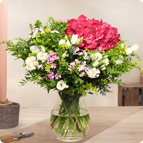 Un bouquet rond coloré avec hortensia fuchsia, lisianthus blanc et feuillage frais. Livraison rapide 7j/7 partout en France.