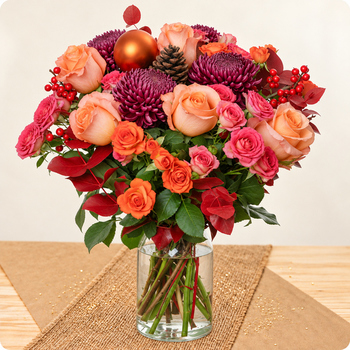 Roses orange, chrysanthèmes bordeaux et touches cuivrées pour un Noël chaleureux