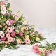 Dessus de cercueil Hymne en triangle avec lys roses, germinis et roses pour hommage floral - 123fleurs