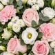 Gerbe à main de deuil Clémence composée de fleurs rose pâle et blanches avec feuillage