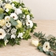 Coussin de deuil rond composé de roses blanches, gerberas blancs et eucalyptus